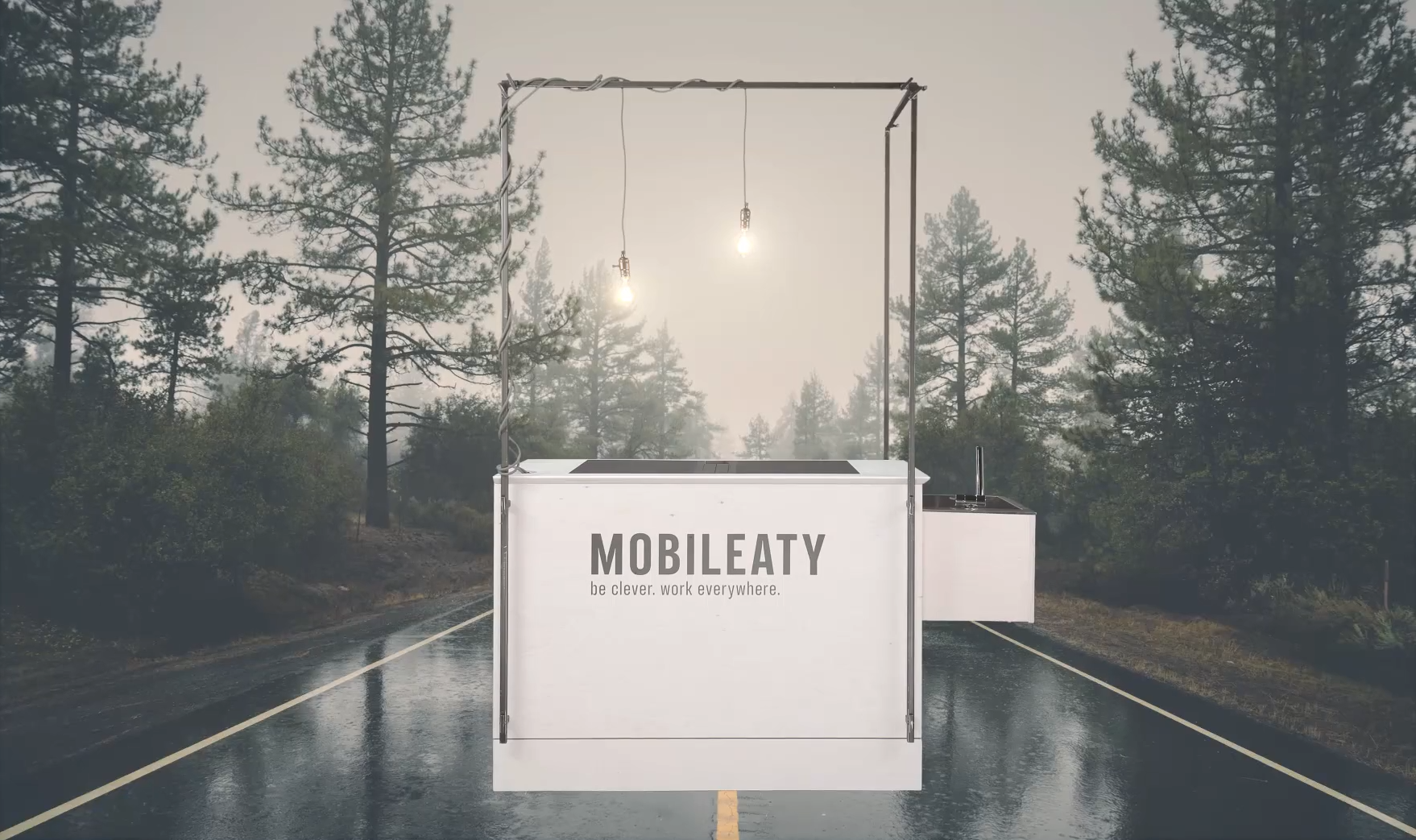 mobile Bar mit Mobileaty Schriftzug auf verregneter Straße in Nadelwald