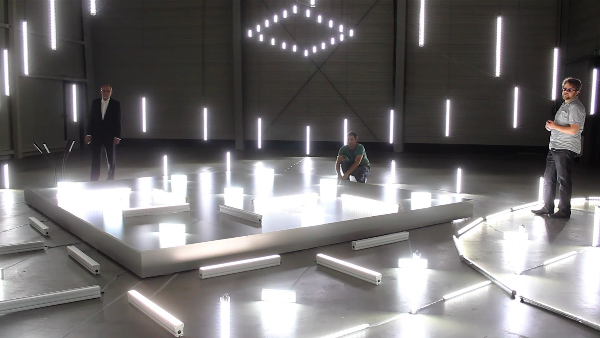 Männer arbeiten an einem großen Set einer Lichtinstallation mit weißen LEDs