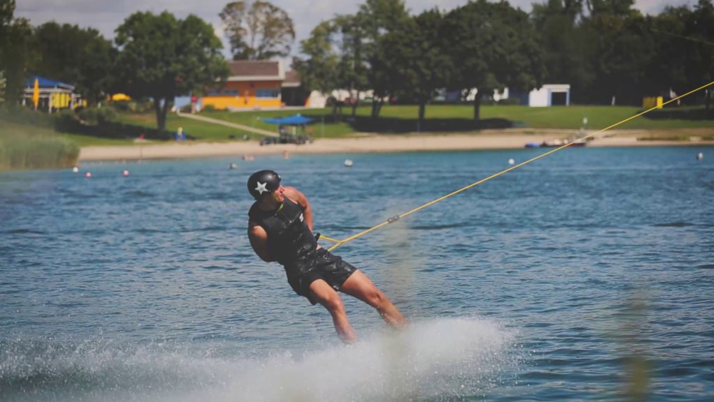 ein Wakeboarder lässt sich auf einem See von einem Seil ziehen