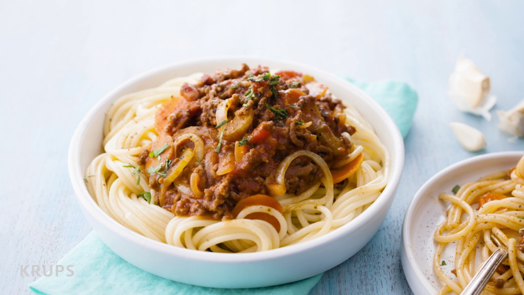 Ein Teller mit Spaghetti Bolognese auf einer blauen Serviette